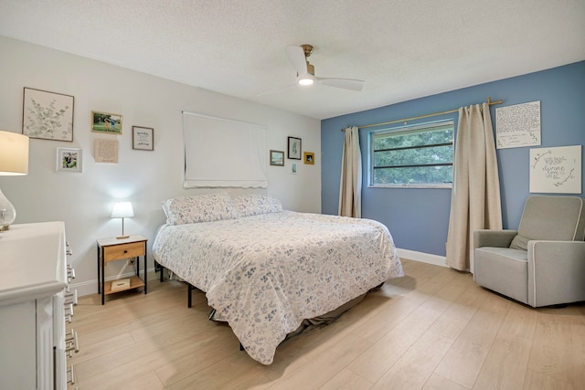 bedroom with ceiling fan, a textured ceiling, and light wood-type flooring