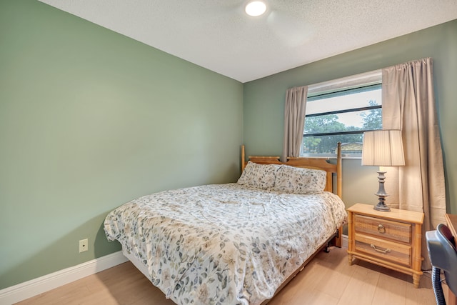 bedroom with hardwood / wood-style floors and a textured ceiling