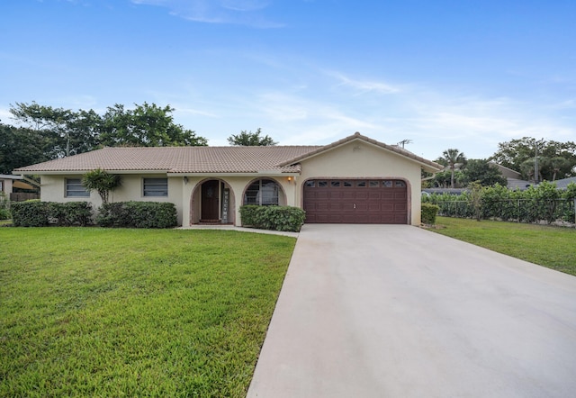 ranch-style home featuring a garage, a tile roof, driveway, stucco siding, and a front yard