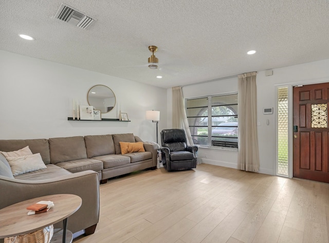 living room featuring a textured ceiling and light wood-type flooring