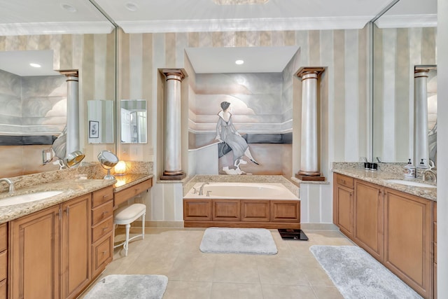 bathroom featuring ornate columns, a bathing tub, tile patterned flooring, and vanity