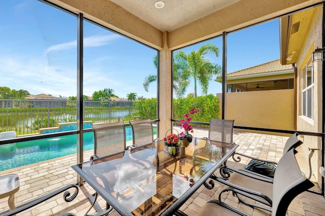 sunroom / solarium featuring a water view