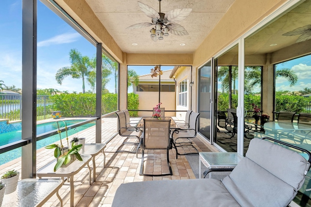 sunroom / solarium featuring ceiling fan and plenty of natural light