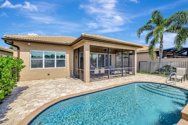 view of pool with a sunroom, ceiling fan, and a patio area