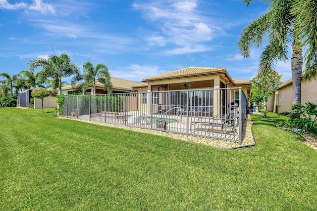 back of house featuring a fenced in pool, a patio, and a lawn