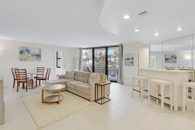 tiled living room with a wall of windows