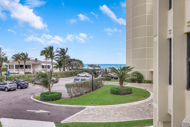 surrounding community featuring a water view and a lawn