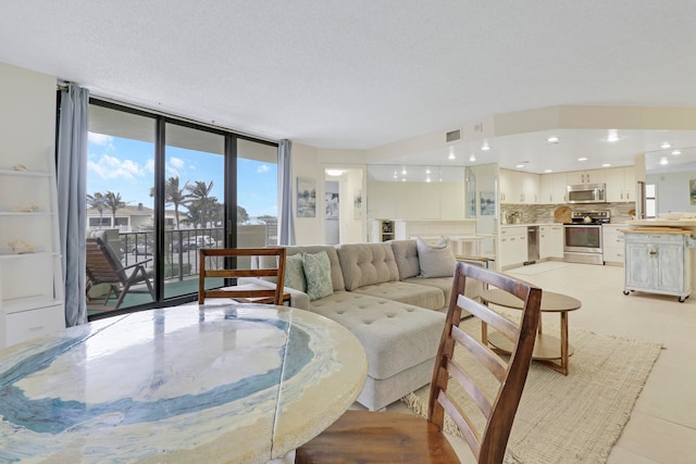 tiled living room with floor to ceiling windows and a textured ceiling