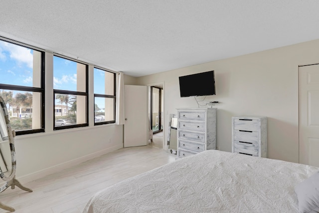 unfurnished bedroom with light wood-type flooring and a textured ceiling