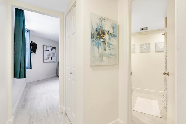 hallway with light hardwood / wood-style floors