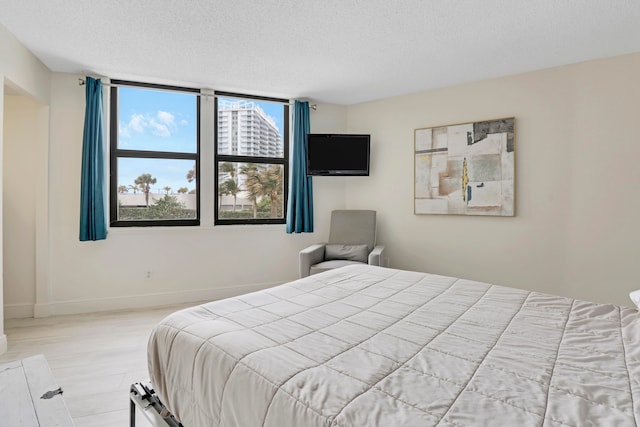 bedroom with a textured ceiling and light wood-type flooring