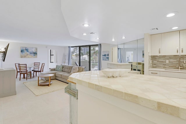 living room featuring sink and light tile patterned floors