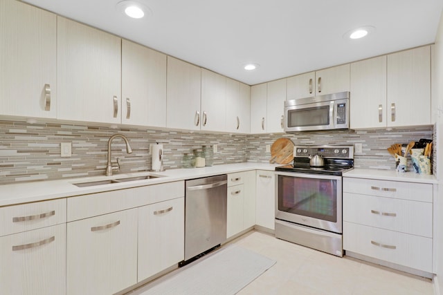 kitchen with light tile patterned floors, stainless steel appliances, backsplash, and sink