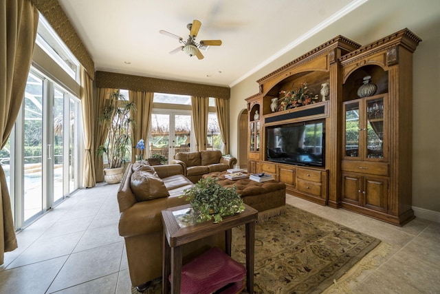 living room with light tile patterned floors, plenty of natural light, ornamental molding, and ceiling fan