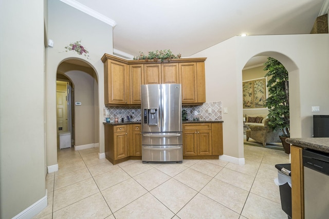 kitchen featuring decorative backsplash, light tile patterned floors, stainless steel appliances, and ornamental molding