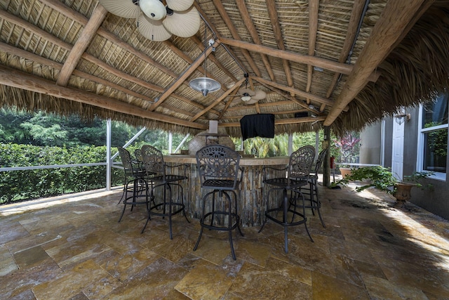 view of patio / terrace featuring a gazebo, ceiling fan, and a bar