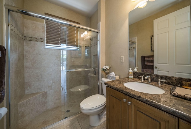 bathroom with tile patterned floors, vanity, an enclosed shower, and toilet