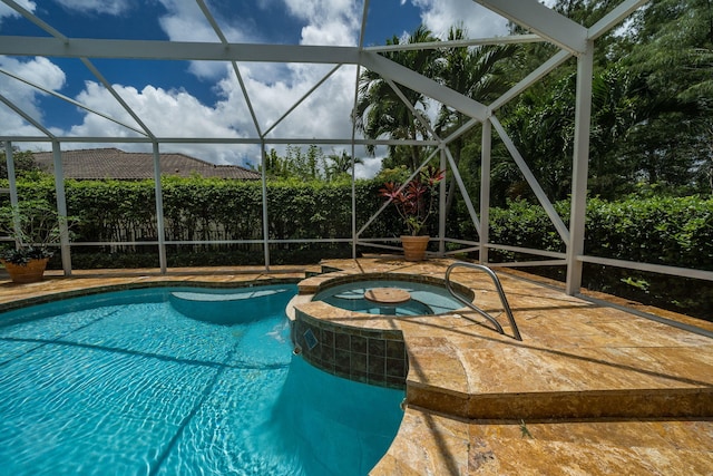 view of swimming pool with an in ground hot tub and a lanai