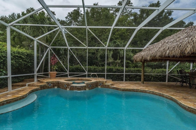 view of pool featuring an in ground hot tub, a patio area, and a lanai