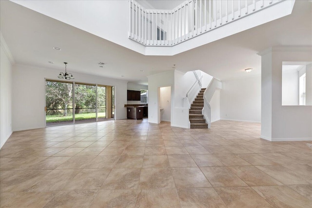 unfurnished living room with light tile patterned flooring, a high ceiling, and a notable chandelier