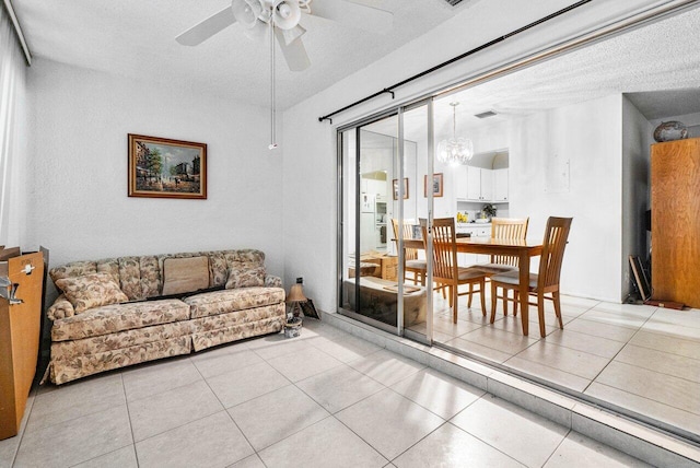 tiled living room featuring a textured ceiling and ceiling fan