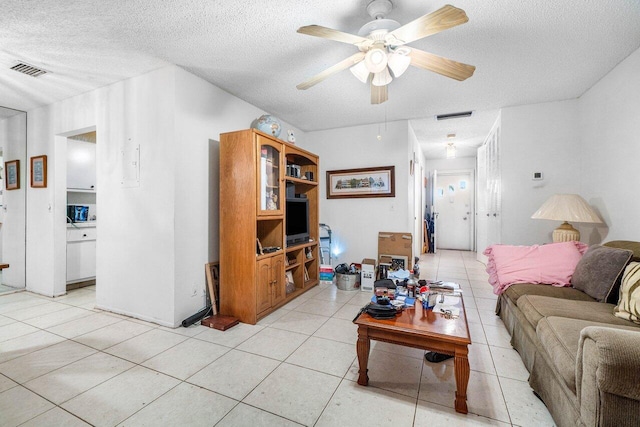 tiled living room with ceiling fan and a textured ceiling