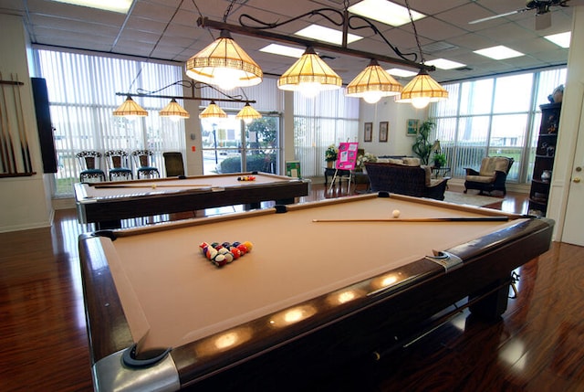 recreation room with hardwood / wood-style flooring, a wall of windows, and billiards