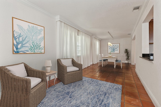 sitting room with dark tile patterned flooring, crown molding, and a textured ceiling