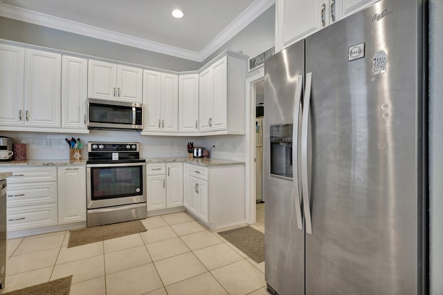 kitchen featuring light stone counters, ornamental molding, white cabinets, appliances with stainless steel finishes, and light tile patterned floors