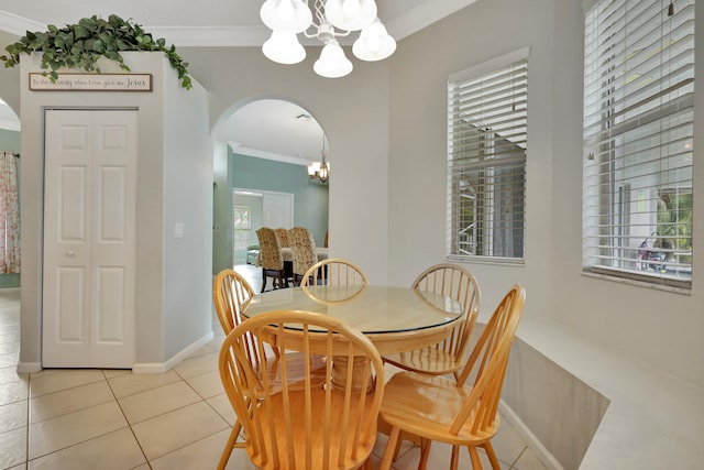 tiled dining area with ornamental molding and a notable chandelier