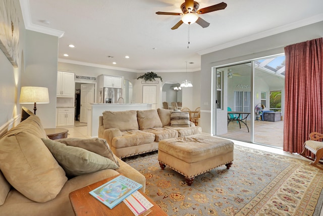 living room featuring a skylight, ceiling fan with notable chandelier, and ornamental molding