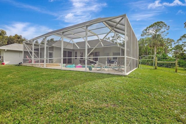 back of house featuring a yard, glass enclosure, and a patio area