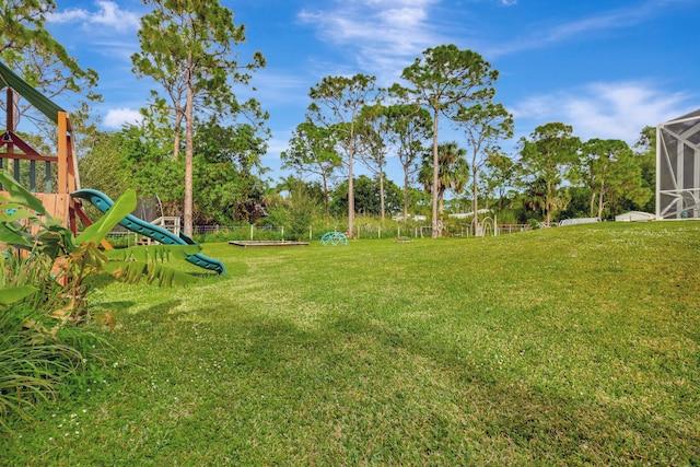 view of yard featuring a playground and a lanai