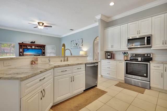 kitchen with tasteful backsplash, sink, ornamental molding, white cabinetry, and appliances with stainless steel finishes