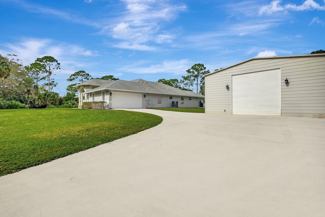 view of side of home featuring an outdoor structure, a garage, and a yard