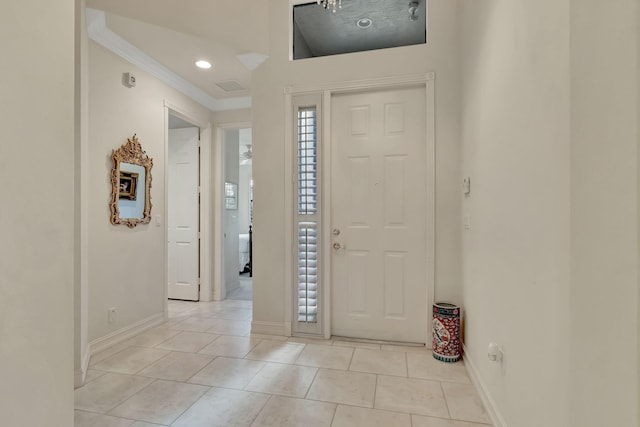 foyer entrance featuring light tile patterned floors and ornamental molding