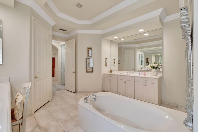 bathroom with a washtub, tile patterned floors, crown molding, a tray ceiling, and vanity