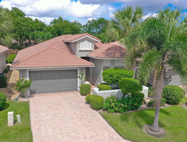 mediterranean / spanish house featuring a front yard and a garage