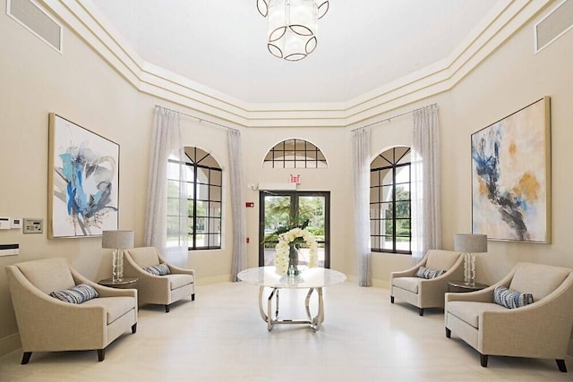 living area with a chandelier and a high ceiling