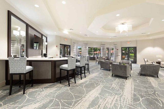 interior space with french doors and a raised ceiling