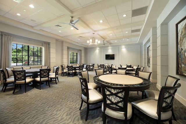 carpeted dining space featuring beamed ceiling, ceiling fan with notable chandelier, and coffered ceiling