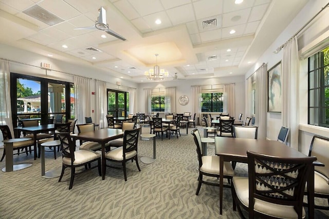 dining room featuring ceiling fan with notable chandelier, light colored carpet, and coffered ceiling