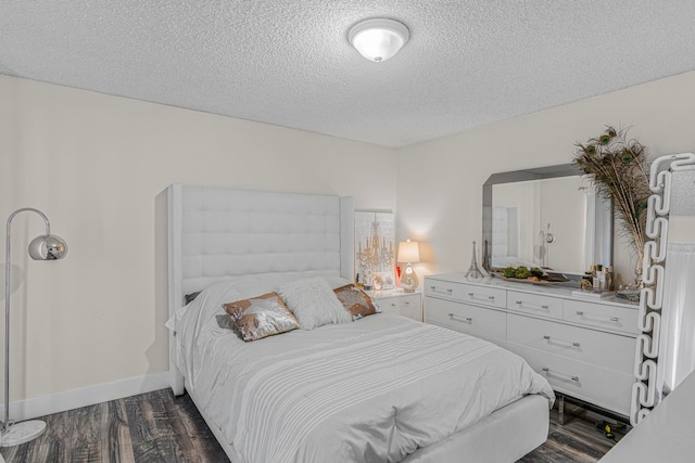 bedroom featuring dark wood-type flooring and a textured ceiling