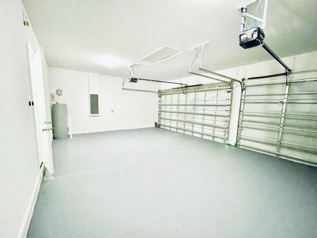 garage featuring electric water heater and a garage door opener