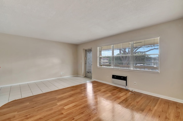 unfurnished room with a textured ceiling and light hardwood / wood-style flooring