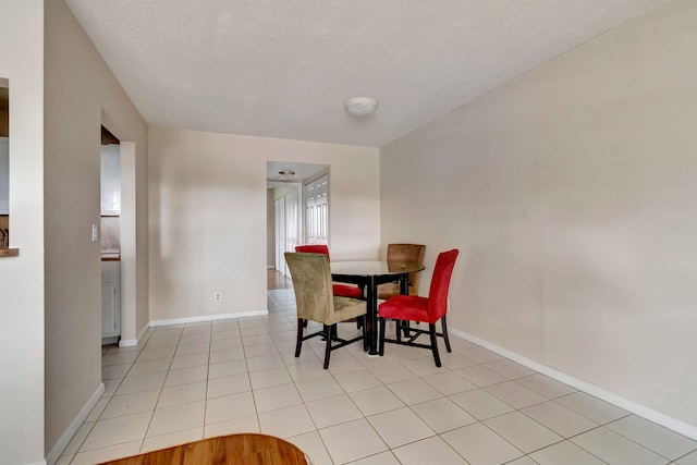 dining room featuring light tile patterned flooring and a textured ceiling