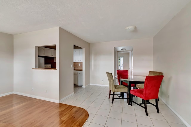 dining room with light hardwood / wood-style floors and a textured ceiling