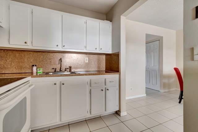 kitchen featuring white cabinets, sink, decorative backsplash, white electric range oven, and light tile patterned floors