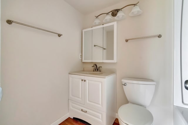 bathroom featuring hardwood / wood-style flooring, vanity, and toilet