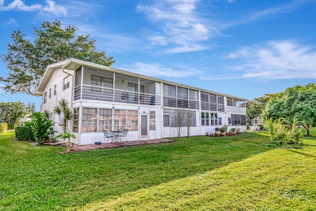 back of house with a patio, a yard, a balcony, and a sunroom